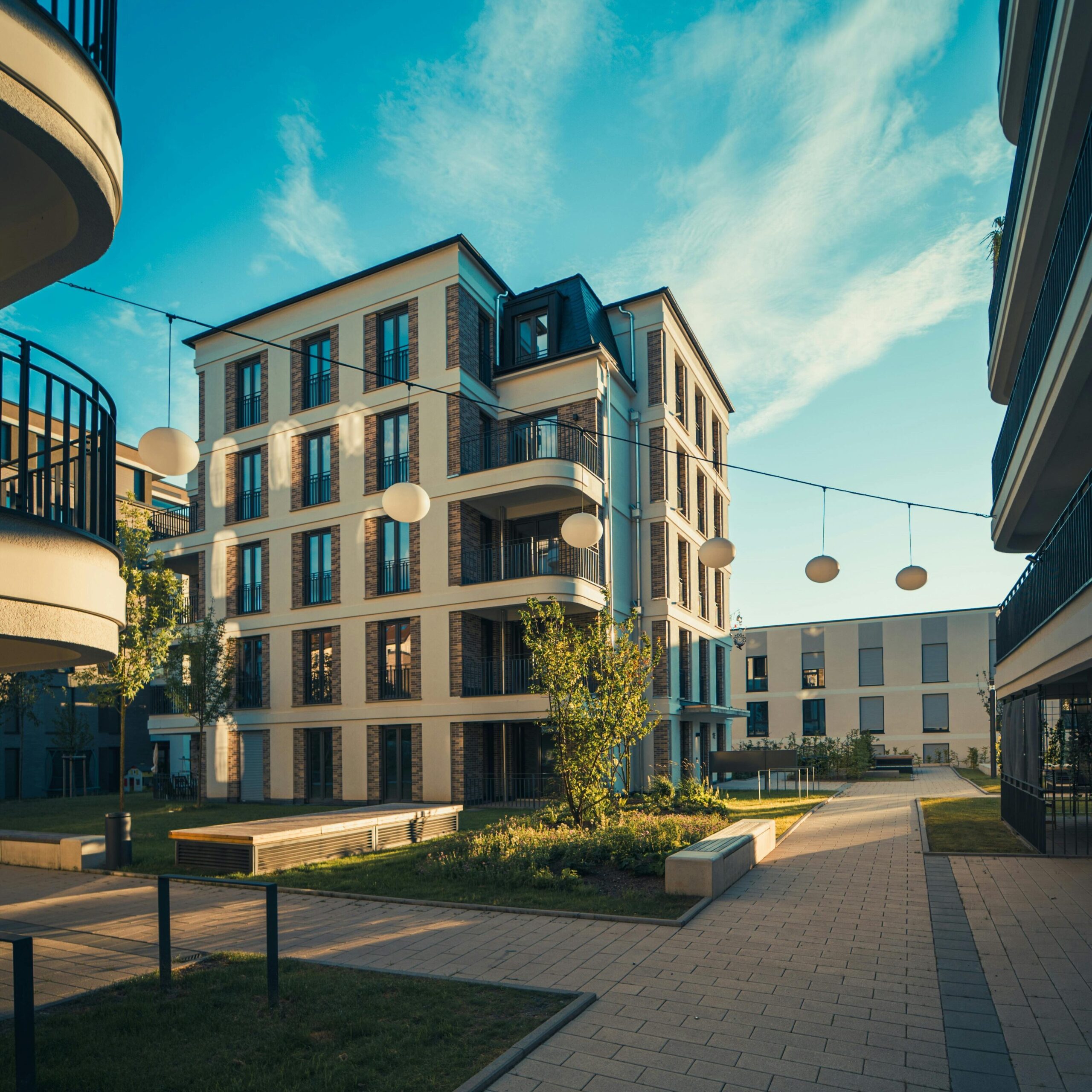 Modern apartment complex under clear blue skies, showcasing contemporary architecture and urban living.